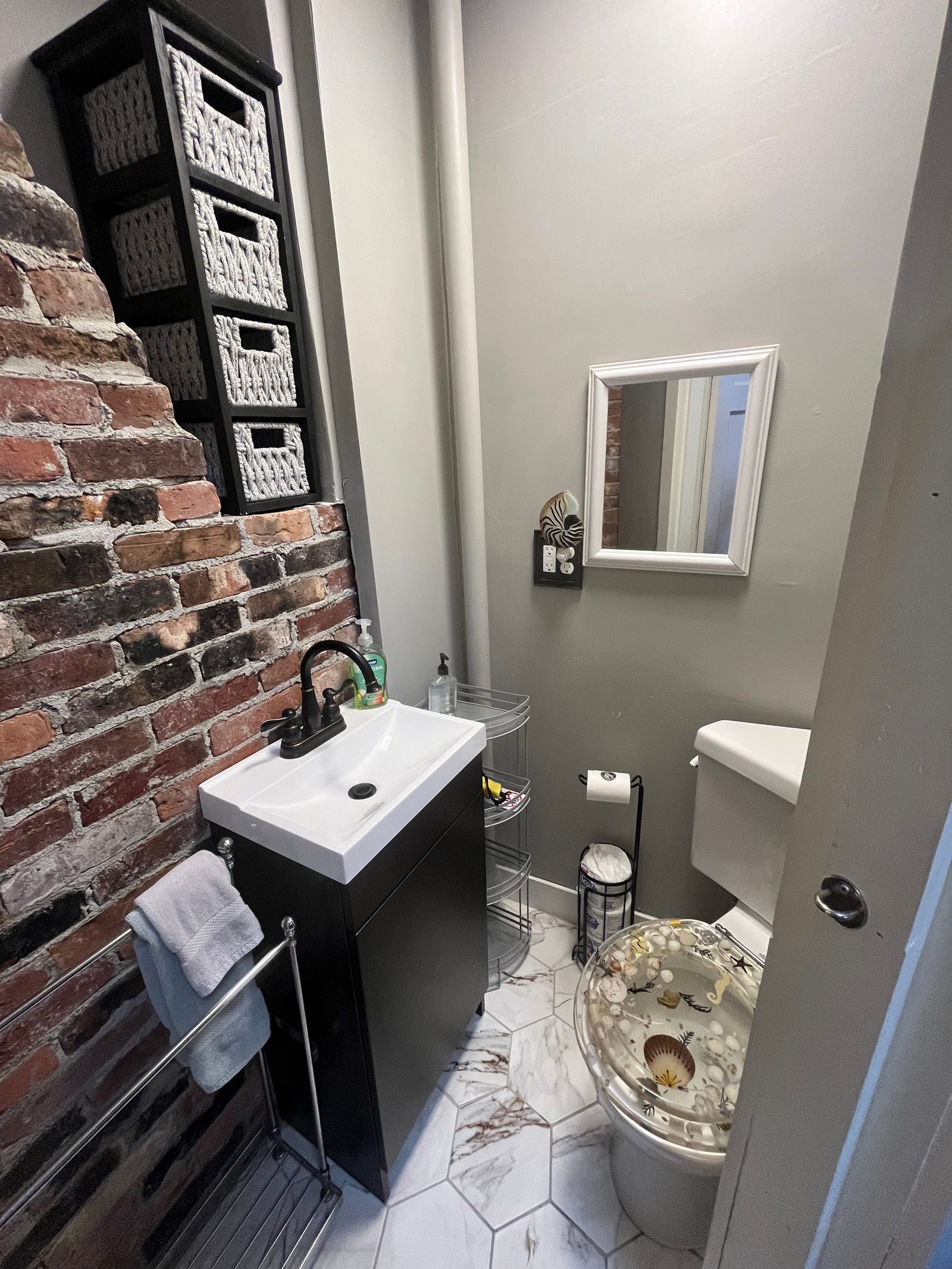 Exposed-brick half-bath in the upstairs apartment